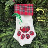 White Christmas stocking with red plaid patterns hanging on a tree